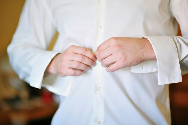 Groom in morning wears white shirt to wedding