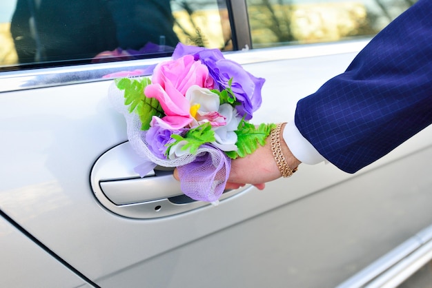 Groom opens wedding car with decorations