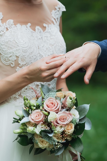 Жених надевает кольцо на руку невесты Фото крупным планом