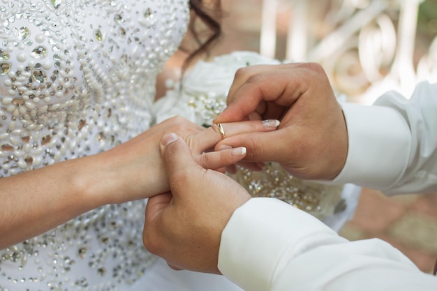 The groom places the ring on the bride's hand Photo closeup