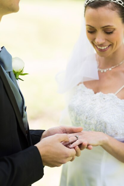 Groom placing ring on brides finger