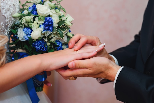 Groom puts on the bride's hand wedding ring