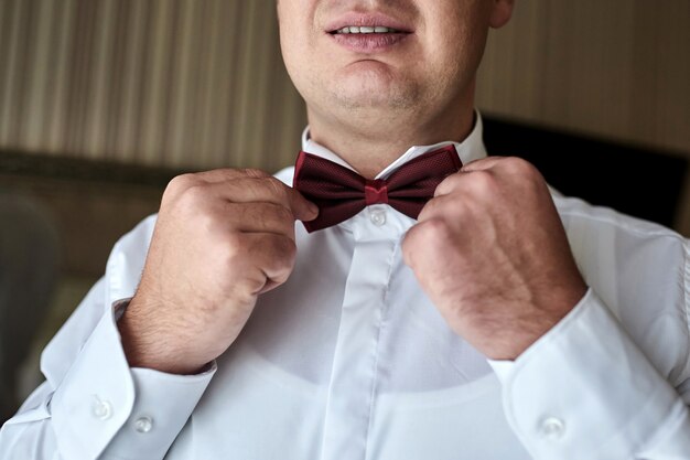 Groom putting on bow tie