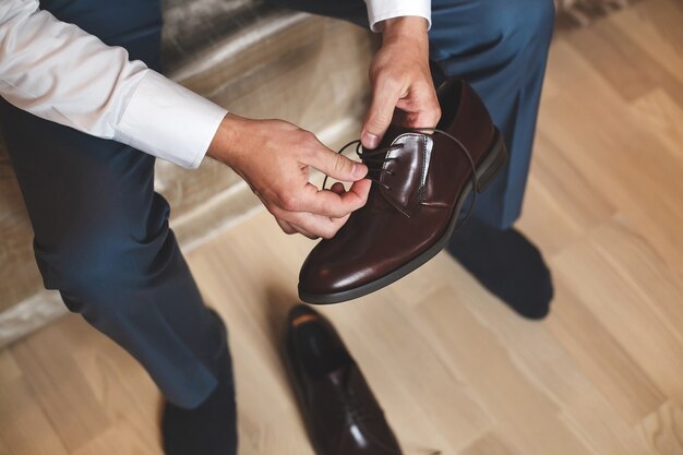 Groom putting his wedding shoes