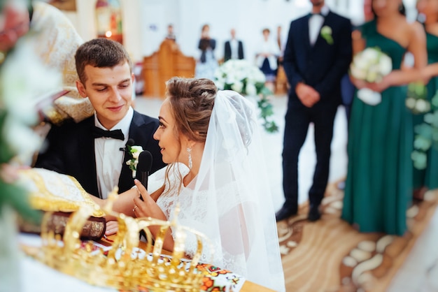 Groom putting a ring on bride's finger during wedding