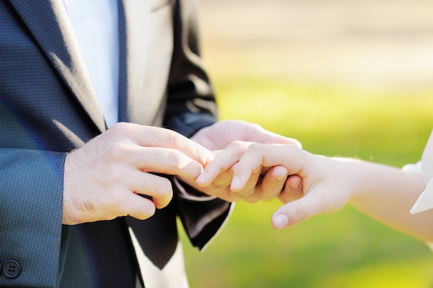 Groom putting a wedding ring on bride's finger