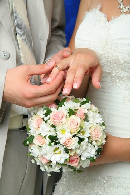 Groom putting wedding ring on bride's finger