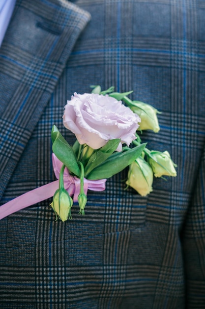 Foto il fiore all'occhiello dello sposo è nella tasca della giacca un garofano lilla nella giacca di un uomo decoro nuziale degli abiti dello sposo