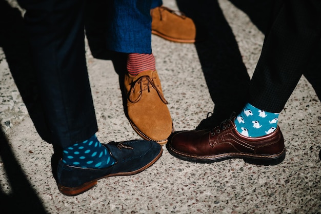 Ноги жениха и жениха в забавных разноцветных носках Мужчины в полосатых носках Яркие винтажные коричневые туфли Модный стиль красоты