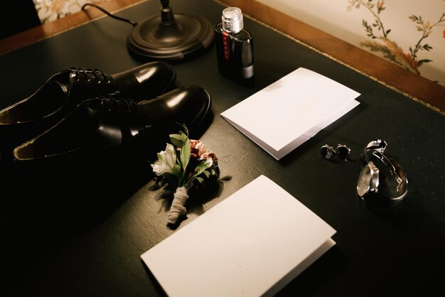 Groom's wedding accessories and invitations on a dark background