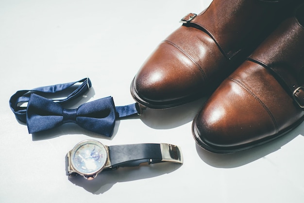 Photo groom shoes and tie on white background