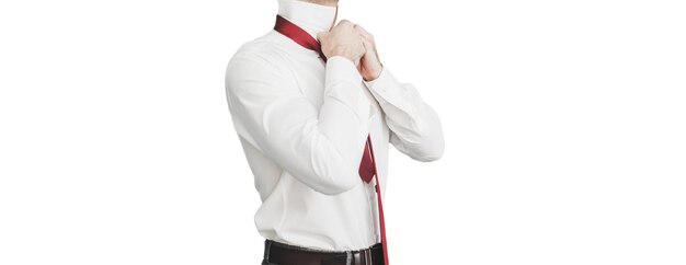 Groom straightens his shirt on white background