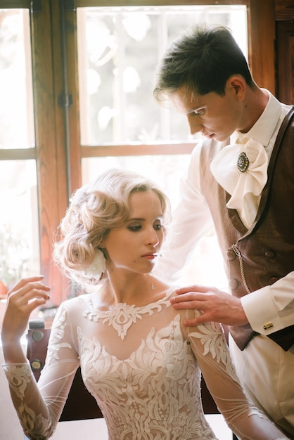 The groom in a suit hugs the bride in a wedding dress