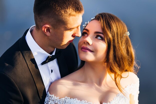 Groom in suit with bow tie bride with beautiful makeup and hair