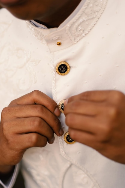 The groom tightens his cufflinks before the wedding