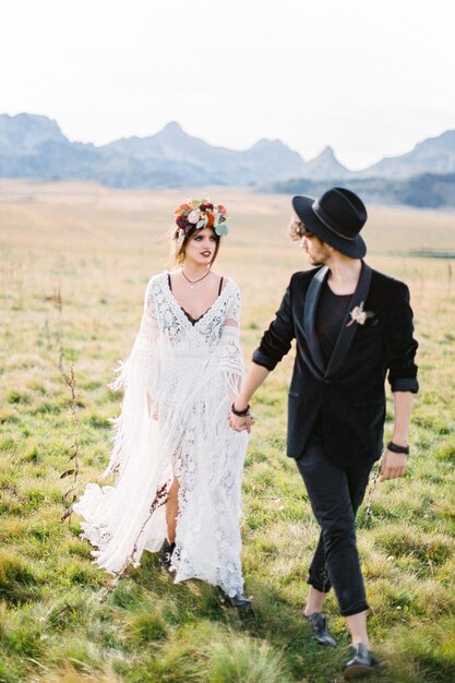 Groom turned to bride walking along the green lawn