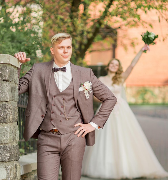 Groom waiting for his bride standing on city street