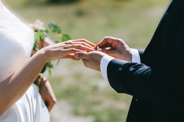 Foto lo sposo indossa la sposa un anello di nozze durante la cerimonia.