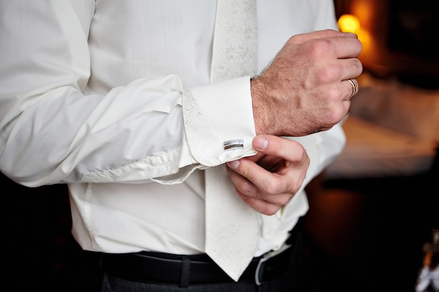 Photo groom wears cufflinks for shirt