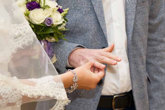 The groom wears an engagement ring to the groom. Dress the wedding ring