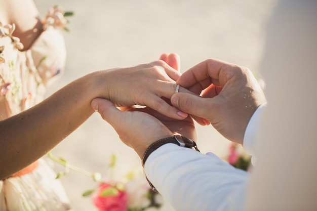 Groom wears ring on bride's finger