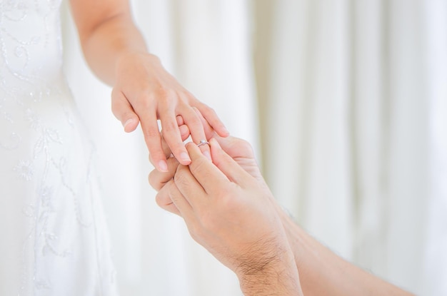 Groom wears a wedding ring to bride in wedding ceremony