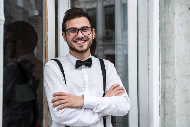 Groom in white shirt smiling by the window. In anticipation of the bride.