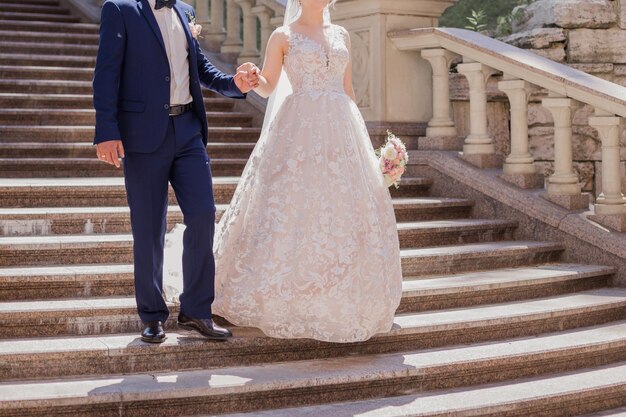 Жених с невестой на большой лестнице в парке