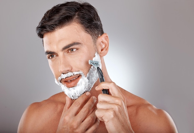 Foto schiuma per toelettatura e rasatura viso uomo con rasoio per bellezza igiene e cura pelle con routine mattutina self care viso e rasatura barba con modella e prodotto in crema per benessere e pulizia