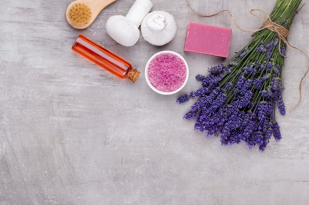 Grooming products and fresh lavender bouquet on white wooden table background.