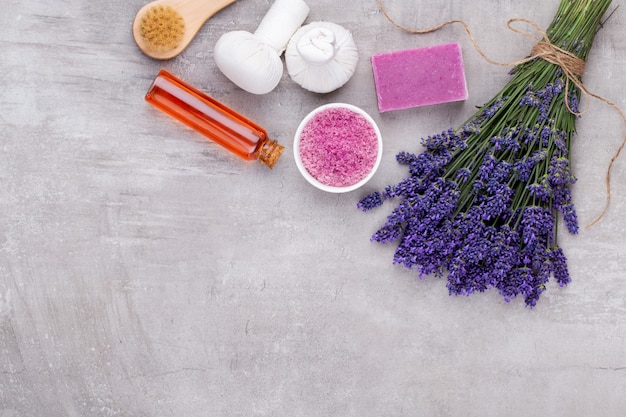 Prodotti per la toelettatura e bouquet di lavanda fresca sulla tavola di legno bianco.