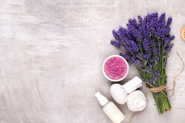 Grooming products and fresh lavender bouquet on white wooden table.