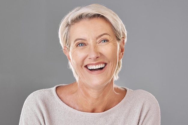 Grooming skincare and face of happy mature woman laughing against a studio grey background Senior female feeling fresh enjoying free time with self care hygiene treatment Joy after routine pamper