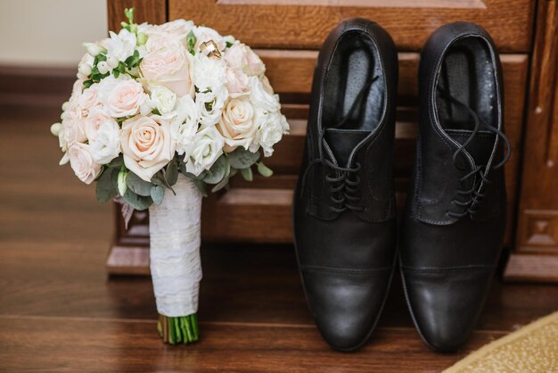 結婚式の日の準備のための新郎のアクセサリー、靴、指輪、花束