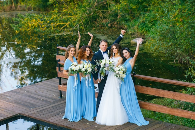 Groomsmen and bridesmaids with newly married on wedding ceremony