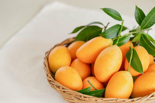 Foto groot formaat verse rijpe biologische zoete gele marian pruim of pruim mango in houten mand