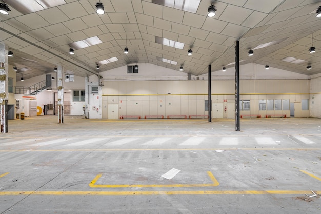 Groot garagegebouw met metalen balken en plafond met ramen en deuren voorbereid voor renovatie