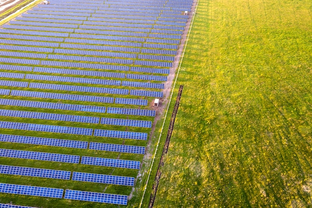 Groot gebied van fotovoltaïsch zonnepaneelensysteem dat hernieuwbare schone energie op groen gras produceert.