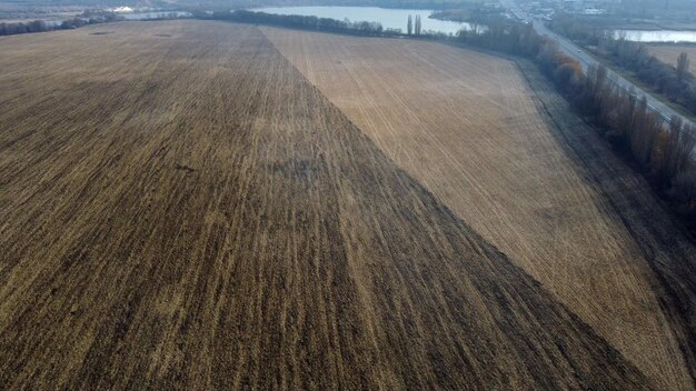 Groot geploegd veld geploegd land geel droog stro na het oogsten van tarwemeer