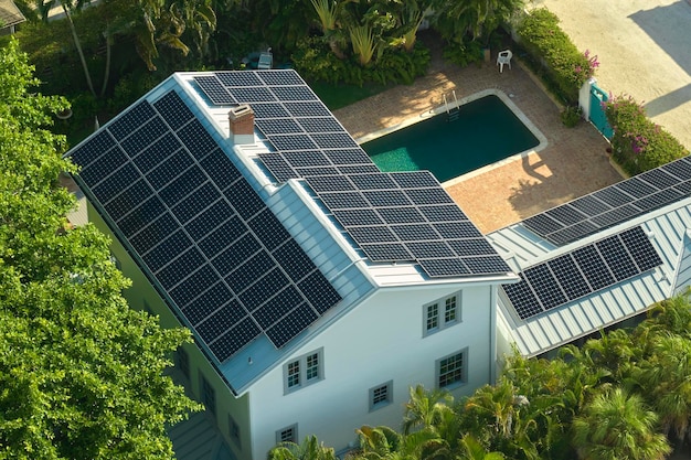 Groot nieuw woonhuis in de Verenigde Staten met een dak bedekt met zonne-fotovoltaïsche panelen voor de productie van schone ecologische elektrische energie in het voorstedelijke platteland Concept van autonoom huis