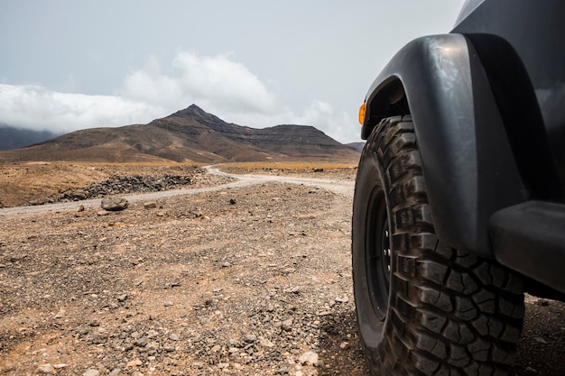 Foto groot off-road wiel van zwarte hoge sterke auto verkent de woestijn en de bergen op het platteland. alternatieve manier van reizen en levensstijl voor reizigers in reislust