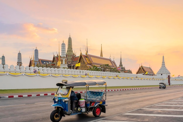 Groot paleis en Wat phra keaw bij zonsondergang Bangkok Thailand Blue Tuk Tuk Thaise traditionele taxi is de voorste scène
