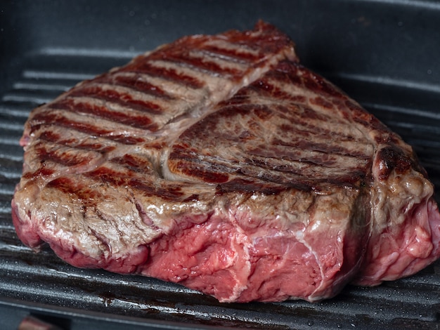 Groot stuk sappig vers rundvlees gebakken aan de ene kant in een pan-grill