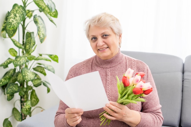 Grootmoeder bedrijf boeket bloemen, glimlachend.