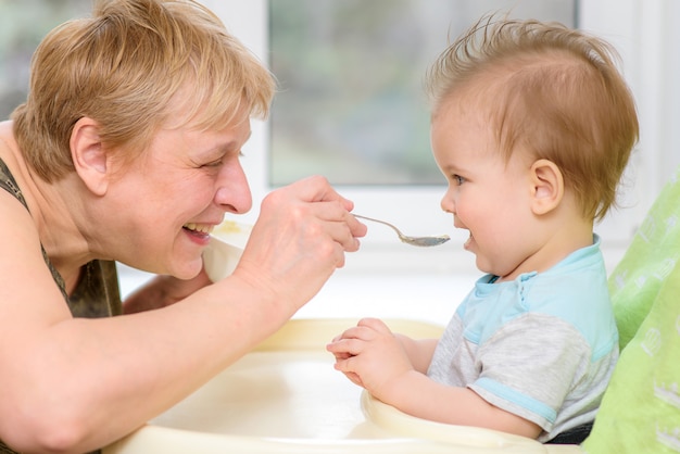 Grootmoeder geeft babyvoeding uit een lepel