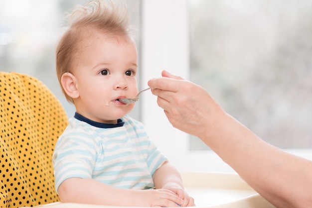 Grootmoeder geeft babyvoeding uit een lepel