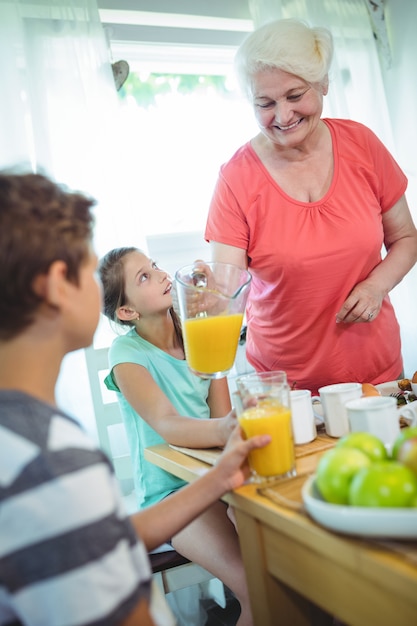 Grootmoeder gietend jus d'orange in glas