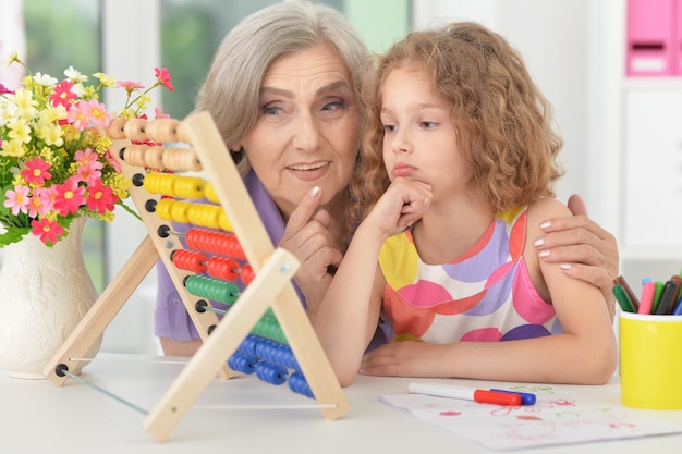 Foto grootmoeder helpt haar kleindochter met huiswerk, educatief concept