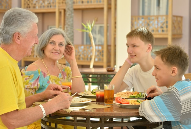 Grootouders met kleinkinderen aan het ontbijt op tropisch resort