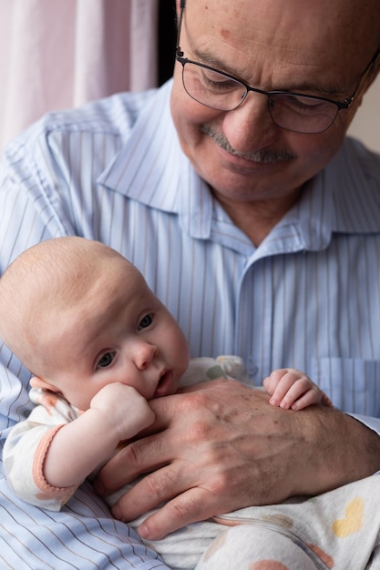 Grootvader die een Kaukasisch pasgeboren babymeisje vasthoudt